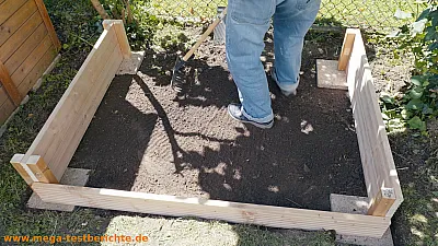 Sandkasten steht auf den vier Steinplatten