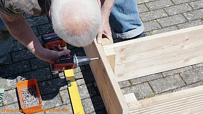 Schraube wird in den Sandkasten geschraubt