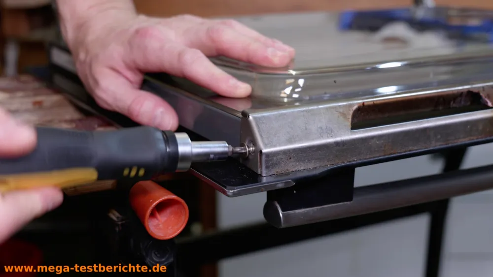 Ofentüre ausbauen -  Schraube an der Blende entfernen