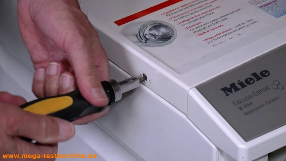 Schraube unter der Plastikabdeckung