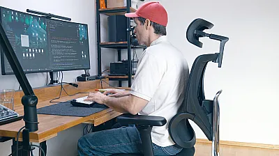 Marco sitzt im CLOUVOU MasterSeat am Schreibtisch